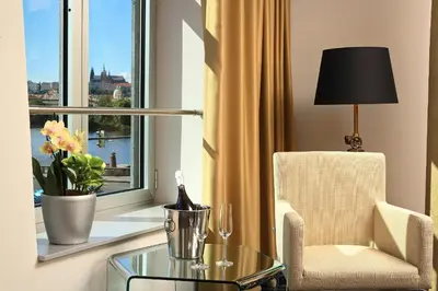 a room with a glass table and a chair and a window at Dancing House - Tančící dům hotel in Prague