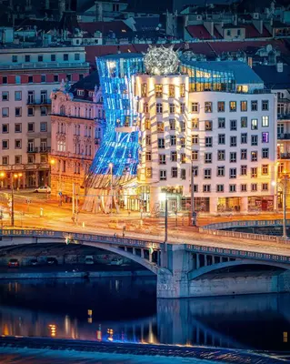 a view of a city at night with a building at Dancing House - Tančící dům hotel in Prague