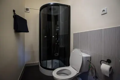 a bathroom with a toilet and a glass shower at Brix Hostel in Prague