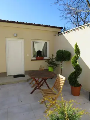 a patio with a wooden table and two chairs at Rivendell Apartments in Prague
