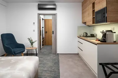 a small kitchen with a blue chair in a room at Hotel Osvit in Mladá Boleslav