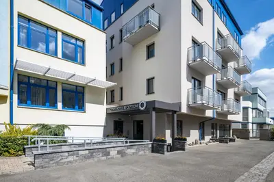 an apartment building with a parking lot in front of it at Hotel Osvit in Mladá Boleslav