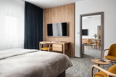 a hotel room with a bed and a desk and a television at Hotel Osvit in Mladá Boleslav