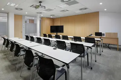a conference room with white tables and black chairs at Hotel Osvit in Mladá Boleslav