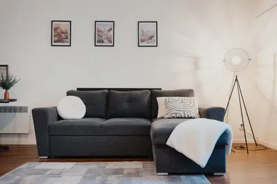 a living room with a couch and a floor fan at Lovely Prague Havanska - with Free Parking in Prague