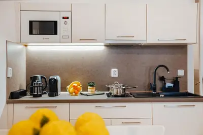 a kitchen with white cabinets and a counter top at Lovely Prague Havanska - with Free Parking in Prague