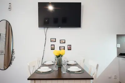 a dining room with a table and a tv on the wall at Lovely Prague Havanska - with Free Parking in Prague