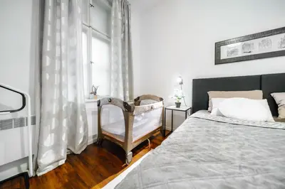a bedroom with a bed and a chair and a window at Lovely Prague Havanska - with Free Parking in Prague