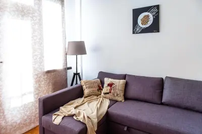 a living room with a purple couch with a dress on it at Stunning Design Apartment in Prague