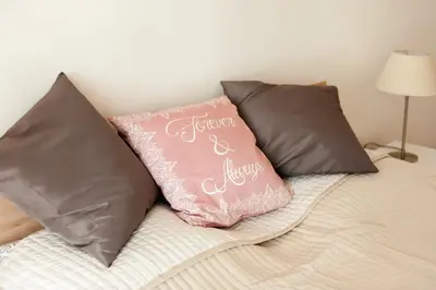 a bed with two pillows and a pink pillow at Stunning Design Apartment in Prague
