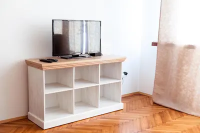 a tv on a white stand in a room at Stunning Design Apartment in Prague