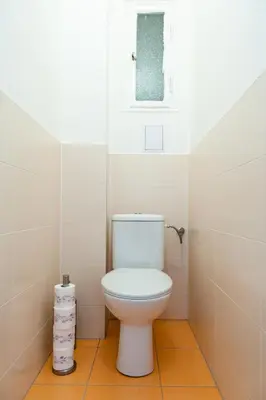 a bathroom with a white toilet and a window at Stunning Design Apartment in Prague