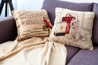 a small dog sitting on a couch with pillows at Stunning Design Apartment in Prague