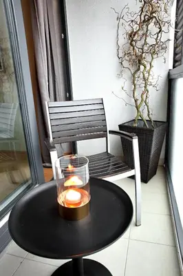 a table with a candle and a chair on a balcony at Brunetti Design Apartment in Prague