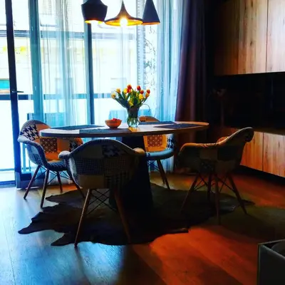 a dining room table with chairs and a vase of flowers on it at Brunetti Design Apartment in Prague