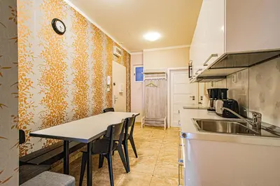 a kitchen with a sink and a table with chairs at Old Town Rybna Apt by Ruterra in Prague
