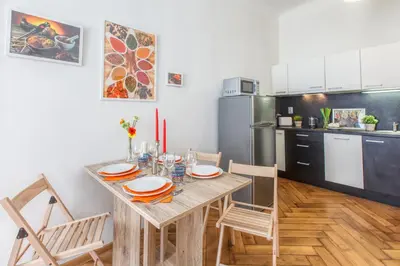 a kitchen with a wooden table and chairs in a room at Modern Apartment Zitna in Prague