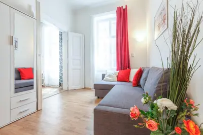 a living room with a gray couch and red pillows at Modern Apartment Zitna in Prague