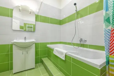 a green and white bathroom with a tub and sink at Modern Apartment Zitna in Prague