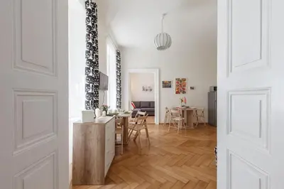 a living room with white walls and a wooden floor at Modern Apartment Zitna in Prague