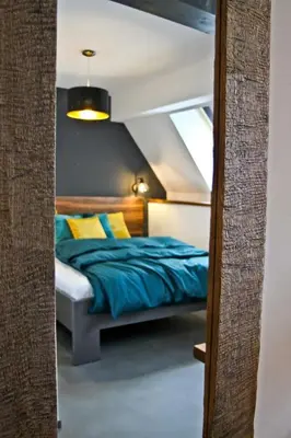 a bedroom with a bed with blue sheets and yellow pillows at Royal Apartmány in Dobříš