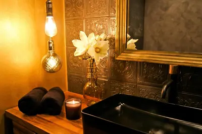 a bathroom with a sink and a mirror and a candle at Royal Apartmány in Dobříš