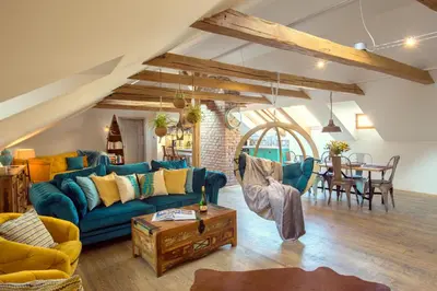 a living room with a blue couch and a table at Bohemian Chic 2 Bedroom 2 Bathroom Loft with Hanging Chair in Prague