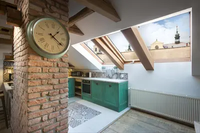 a kitchen with a clock on a brick wall at Bohemian Chic 2 Bedroom 2 Bathroom Loft with Hanging Chair in Prague