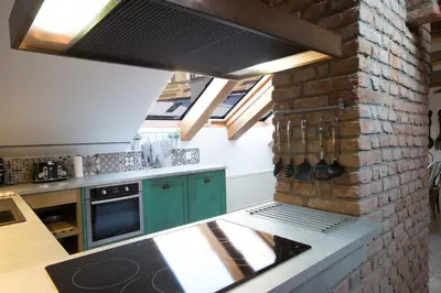 a kitchen with green cabinets and a brick wall at Bohemian Chic 2 Bedroom 2 Bathroom Loft with Hanging Chair in Prague