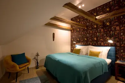 a bedroom with a large bed and a chair at Bohemian Chic 2 Bedroom 2 Bathroom Loft with Hanging Chair in Prague