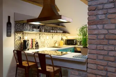 a kitchen with a counter with two chairs and a sink at Bohemian Chic 2 Bedroom 2 Bathroom Loft with Hanging Chair in Prague