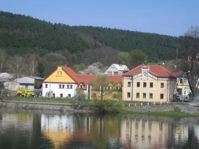 a group of buildings next to a body of water at Penzion Paták in Kamýk nad Vltavou