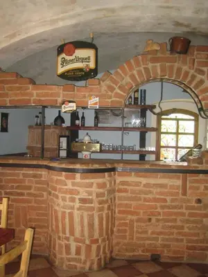 a bar in a restaurant with a brick wall at Penzion Paták in Kamýk nad Vltavou