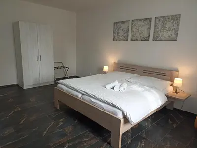 a bedroom with a bed with two stuffed animals on it at Penzion U tri statkaru in Dobříš