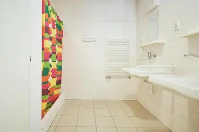 a white bathroom with a sink and a mirror at Hostel Mikoláše Alše in Prague