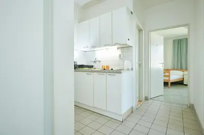 a white kitchen with white cabinets and a room at Hostel Mikoláše Alše in Prague