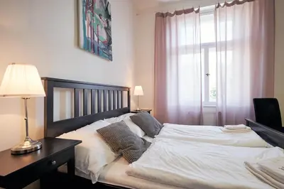 a bedroom with a bed and a desk and a window at Hostel Mikoláše Alše in Prague