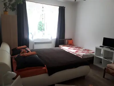 a bedroom with a large bed and a window at Apartmány Karlštejn in Karlštejn