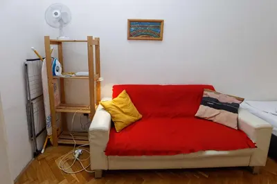 a living room with a red couch with pillows on it at Apartments Truhlarska 31 in Prague