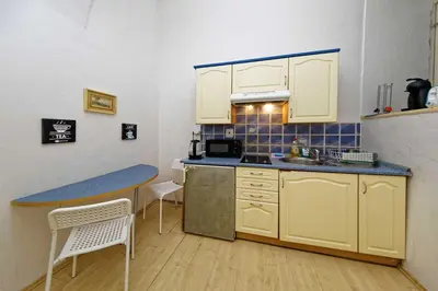 a small kitchen with yellow cabinets and a table at Apartments Truhlarska 31 in Prague