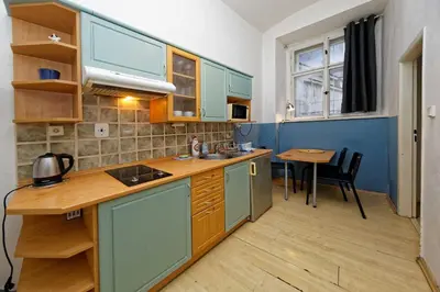 a small kitchen with blue cabinets and a table at Apartments Truhlarska 31 in Prague