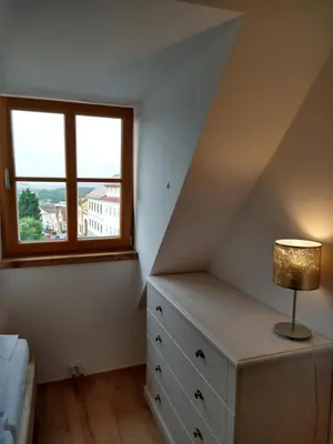 a bedroom with a bed and a dresser and a window at Apartmány Malý mnich in Mníšek pod Brdy
