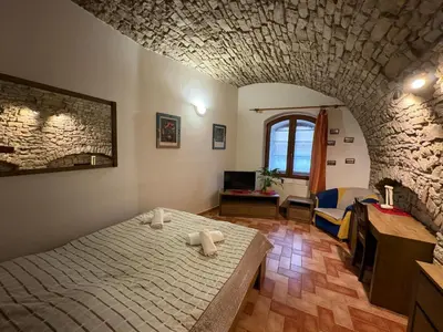 a bedroom with a bed and a stone wall at Penzion Na Hradbách in Louny