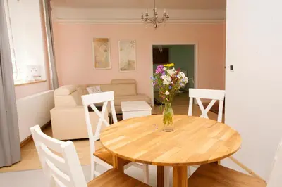 a dining room table with a vase of flowers on it at Art Nouveau Apartment in Prague