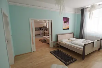 a bedroom with a bed and a living room at Art Nouveau Apartment in Prague