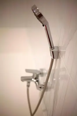 a faucet attached to a wall with a sink at Art Nouveau Apartment in Prague