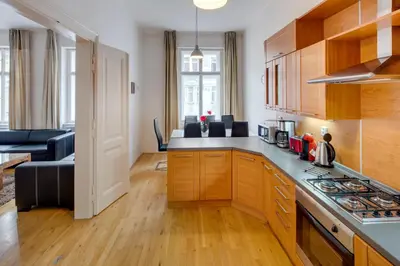 a kitchen with wooden cabinets and a stove top oven at Old Town Square Apartments in Prague