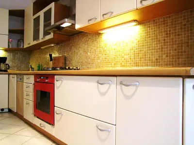 a kitchen with white cabinets and a red microwave at Old Town Square Apartments in Prague