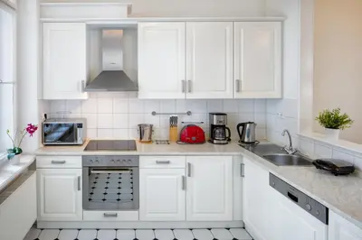 a white kitchen with white cabinets and a sink at Old Town Square Apartments in Prague