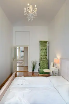 a bedroom with a large white bed and a chandelier at Old Town Square Apartments in Prague